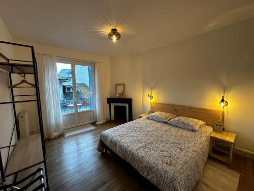 une chambre avec un lit et une fenêtre dans l'établissement Belle maison de ville au cœur du village de montagne, à Vic-sur-Cère