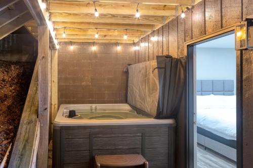 ein kleines Bad mit einer Badewanne und einem Bett in der Unterkunft Amber Escape by AvantStay 3 Unique Spaces Pool in Jefferson City
