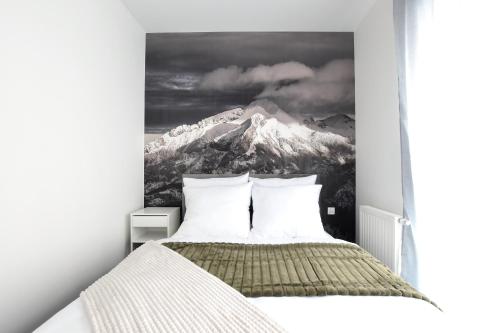a bed in a room with a picture of a mountain at MagicSki Wisła in Wisła