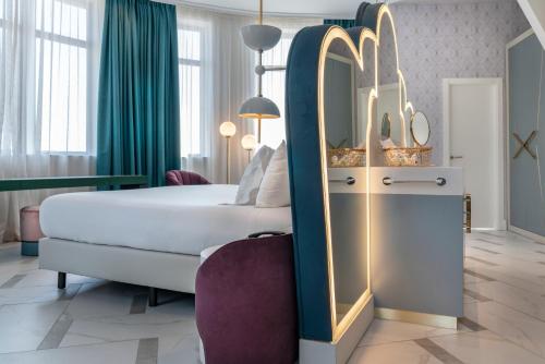 a hotel room with a large bed and a mirror at Vincci Capitol in Madrid