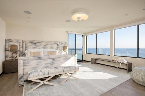 a bedroom with a bed and large windows at Matador by AvantStay Ocean Front Malibu Pad w Rooftop Patio in Topanga