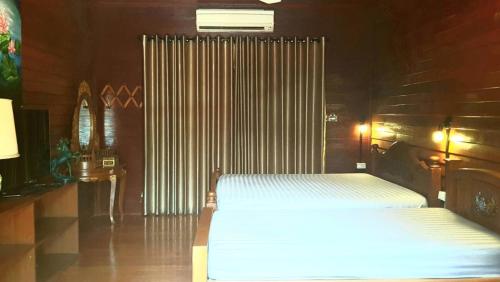 a bedroom with two twin beds and a radiator at Baan mansin บ้านม่านศิลป์ in Pak Chong