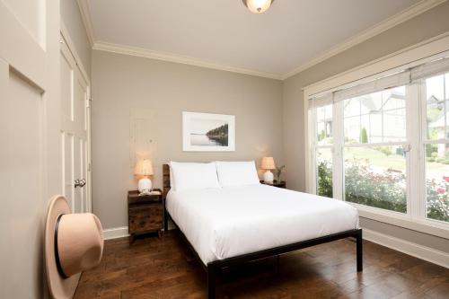 een slaapkamer met een wit bed en een raam bij Sweetgum by AvantStay Black Mountain Retreat w Covered Deck in Black Mountain