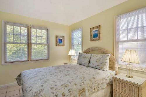 a bedroom with a bed and two windows at A Little Slice Of Paradise by AvantStay Communal Pool Screened in Porch Great Location Month Long Stays in Stock Island