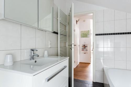 bagno bianco con lavandino e specchio di Ferienwohnung Ettelsberg in Willingen a Willingen