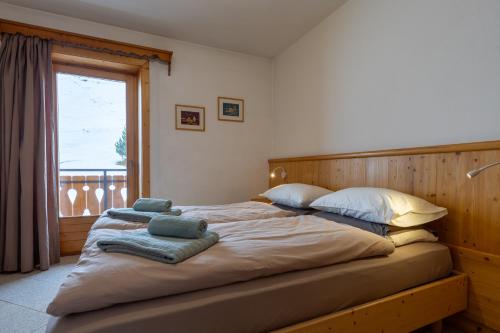 Un dormitorio con una cama grande con toallas. en Black Lake Studios - Trepalle, en Livigno