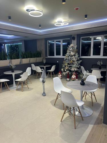 a christmas tree in a room with tables and chairs at Guest House Zatyshnyi Dvir in Bukovel