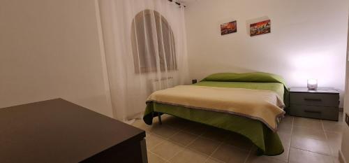 um quarto com uma cama verde e uma mesa em Al focolare di Enzo em Marino