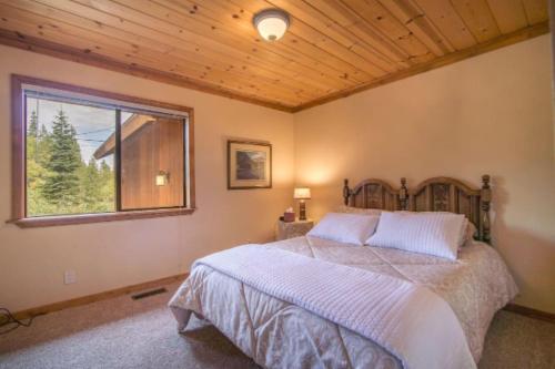 een slaapkamer met een groot bed en een raam bij Whiskey Springs by AvantStay Classic Cabin Near Tahoe Donner Ski Area in Truckee