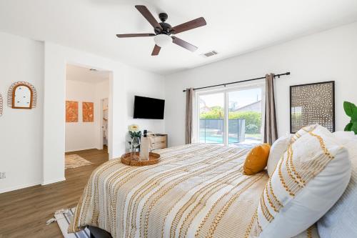 a bedroom with a bed with a ceiling fan at Sunny Palms by AvantStay Near Empire Polo Club in Indio