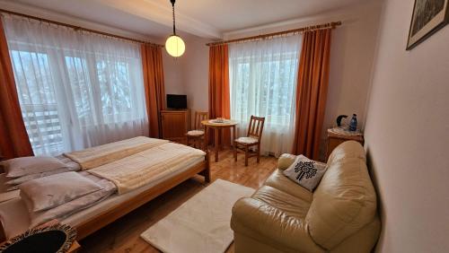 um quarto com uma cama e um sofá em SIEDLISKO HARENDA BIESZCZADY em Czarna
