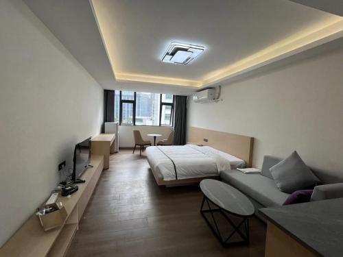 a hotel room with a bed and a couch at Weisu Service Apartment - Shenzhen Songpingshan Science and Technology Park Store in Shenzhen