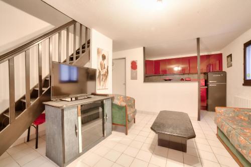 un salon avec un escalier et une cuisine dans l'établissement Douces vacances à La Tranche-sur-Mer, à La Tranche-sur-Mer