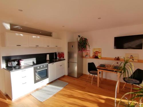 a kitchen with white cabinets and a table with chairs at #HeimatLiebe in Imst