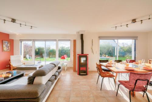un salon avec un canapé, une table et des chaises dans l'établissement Pays Bigouden, maison pour 8 avec piscine, à Plonéour-Lanvern