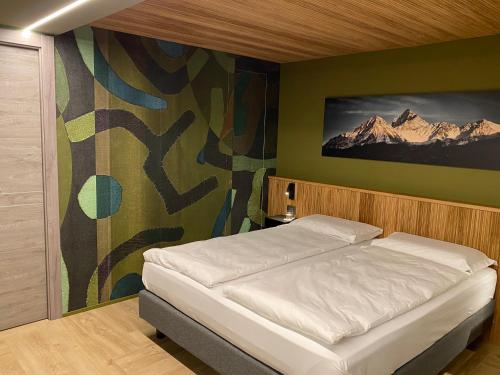 - une chambre avec un lit orné d'une peinture murale dans l'établissement Sui Generis - Aosta Urban Apartments, à Aoste