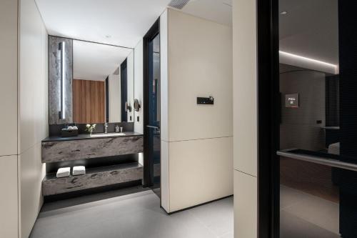 a bathroom with a sink and a mirror at Intercity Hotel Futian Zhongzhou Bay in Shenzhen