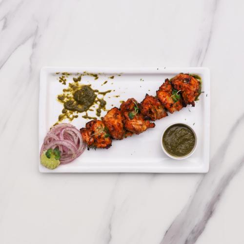 a white plate with some food on a table at Lemon Tree Hotel, Hisar in Hisār