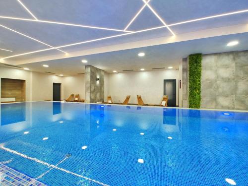 a large swimming pool in a hotel room at Apartman Primus Zlatibor sa bazenom,spa&wellness centrom-Velika recepcija 125 in Zlatibor
