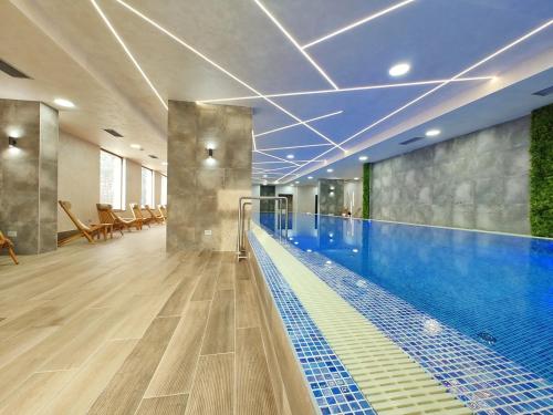 a large swimming pool in a building with a swimming pool at Apartman Primus Zlatibor sa bazenom,spa&wellness centrom-Velika recepcija 125 in Zlatibor