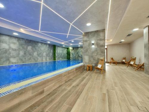 a swimming pool in a gym with a swimming pool at Apartman Primus Zlatibor sa bazenom,spa&wellness centrom-Velika recepcija 125 in Zlatibor