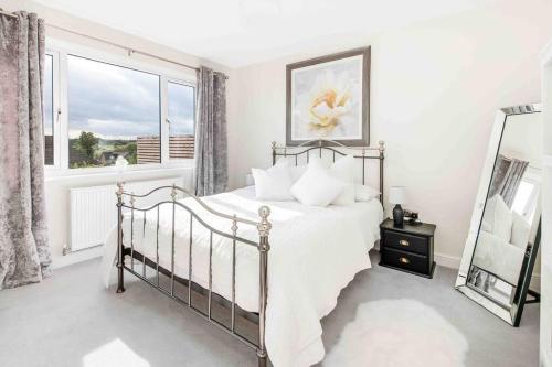 a white bedroom with a bed and a window at Views over Fairburn Ings West Yorkshire in Fairburn