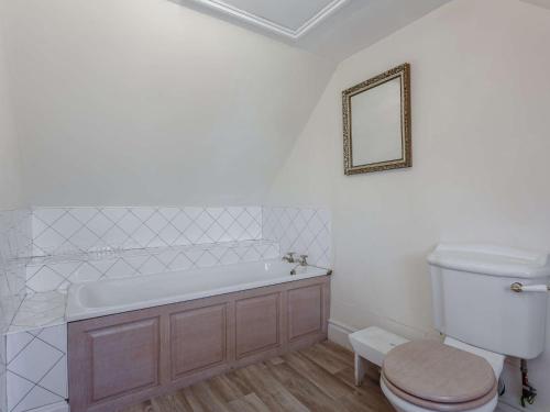 bagno con vasca, servizi igienici e specchio di 3 Bed in Turriff 75489 a Turriff