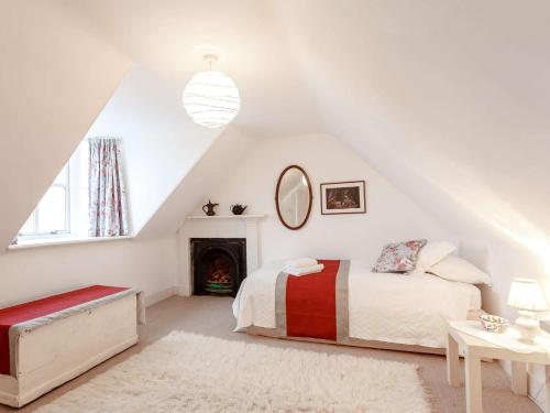 a white bedroom with a bed and a fireplace at 3 Bed in Turriff 75489 in Turriff