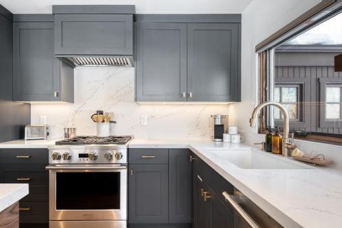 a kitchen with gray cabinets and a sink at Quicksilver by AvantStay Park City Town House in Great Location in Park City
