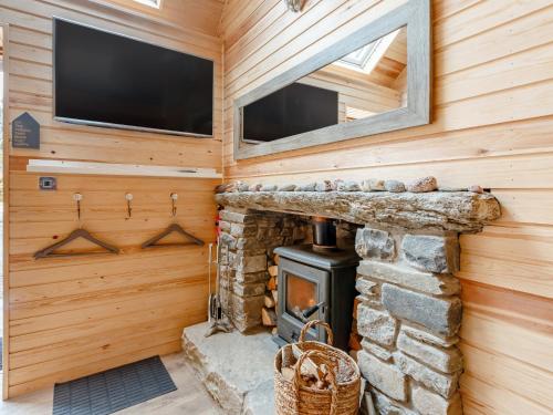 a log cabin with a fireplace and a flat screen tv at 1 Bed in Pitlochry 75678 in Pitlochry