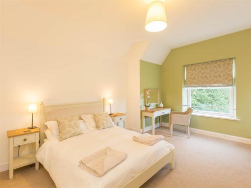 a bedroom with a bed and a desk and a window at 4 Bed in Coldingham CA256 in Coldingham