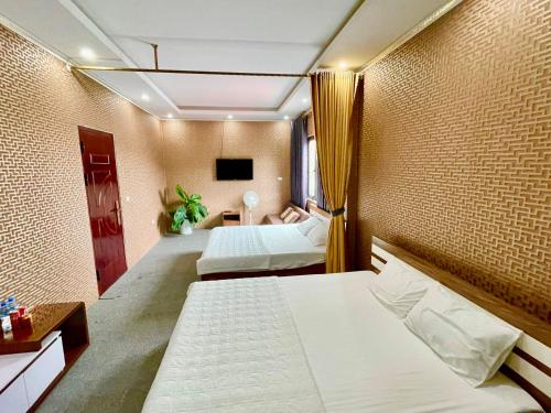 a hotel room with two beds and a television at Cô Chung Hotel in Lao Cai