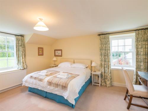 a bedroom with a bed and two windows at 4 Bed in Ancrum CA035 in Saint Boswells