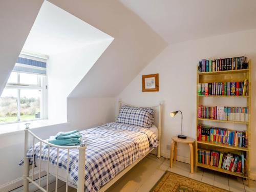a bedroom with a bed and a book shelf with books at 3 Bed in Brodick 77585 in Brodick