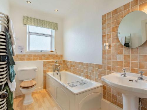 a bathroom with a tub and a sink and a toilet at 2 Bed in Auldearn CA144 in Nairn