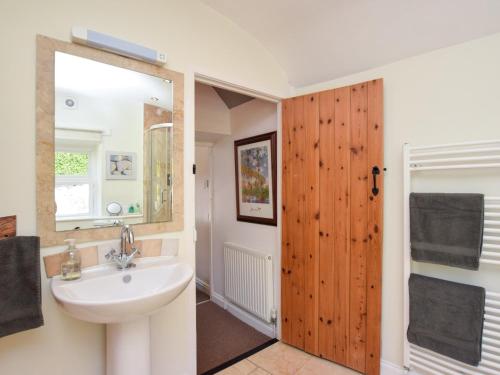uma casa de banho com um lavatório e uma porta de madeira em 1 Bed in Wirksworth 78309 em Wirksworth