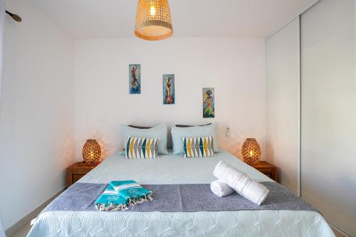 a bedroom with a large bed with two lamps at Coucher de soleil sur le lagon 4 à 5p avec piscine in Marigot