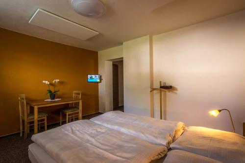 a bedroom with a bed and a table and a desk at Ubytovňa Pali in Kežmarok