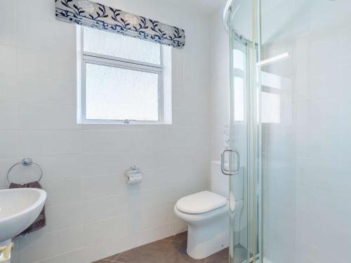 a bathroom with a toilet and a sink and a window at 3 bed in Auldearn CA209 in Nairn
