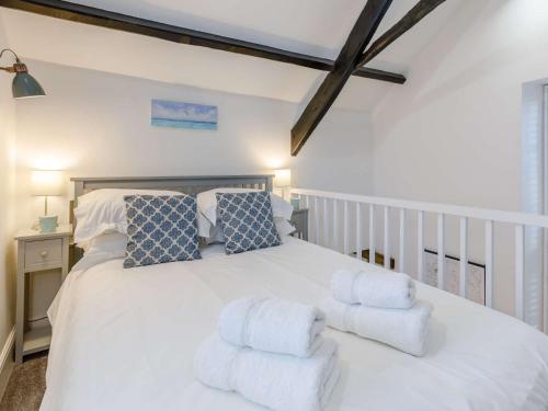a bedroom with a white bed with blue and white pillows at 1 Bed in Bude 75045 in Kilkhampton