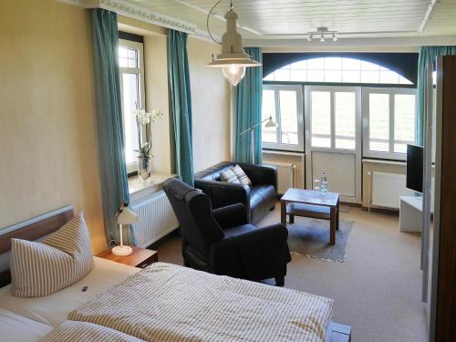 a bedroom with a bed and a couch and a chair at Hus Kiek in de See in Cuxhaven