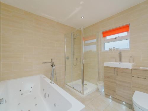La salle de bains est pourvue d'une baignoire, d'une douche et d'un lavabo. dans l'établissement 5 Bed in Mold 79345, à Llanferres