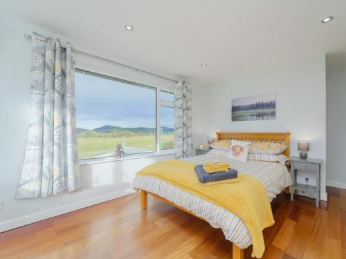 a bedroom with a bed and a large window at 5 Bed in Mold 79345 in Llanferres