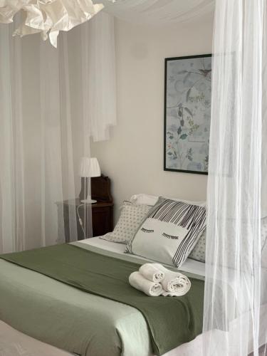1 dormitorio con 1 cama con toallas en Appartamenti di Casa VerbaVolant en Siracusa