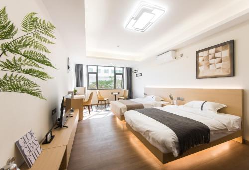 a bedroom with two beds and a table and chairs at Weisu Service Apartment - Shenzhen Songpingshan Science and Technology Park Store in Shenzhen