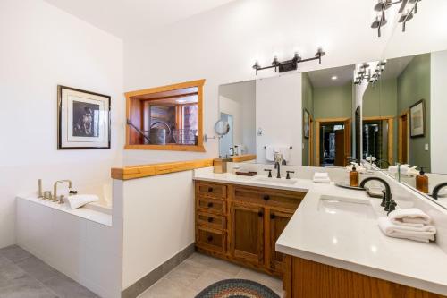 a bathroom with two sinks and a large mirror at Snowdrift Cabin by AvantStay Breathtaking Home w Prime Ski Access Hot Tub in Telluride