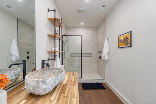 ein Badezimmer mit einer großen Badewanne und einer Dusche in der Unterkunft Dark Horse by AvantStay Hot Tub Balcony Views in Sevierville