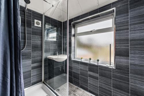 a bathroom with a tub and a sink and a window at Enchanting Abode in Cambridge - Pet Friendly! in Cherry Hinton