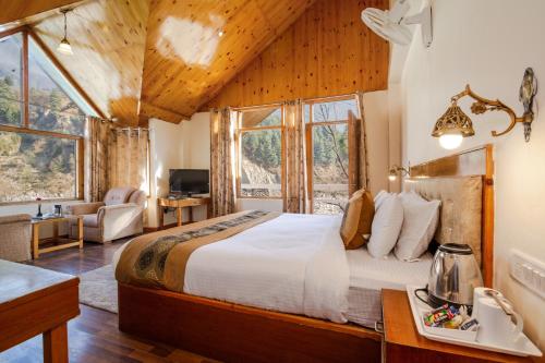 1 dormitorio con 1 cama grande en una habitación con ventanas en Vaayu Resorts And Spa, en Haripūr