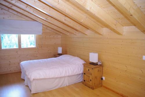 a bedroom with a bed in a wooden room at Télémark 7 in Zinal